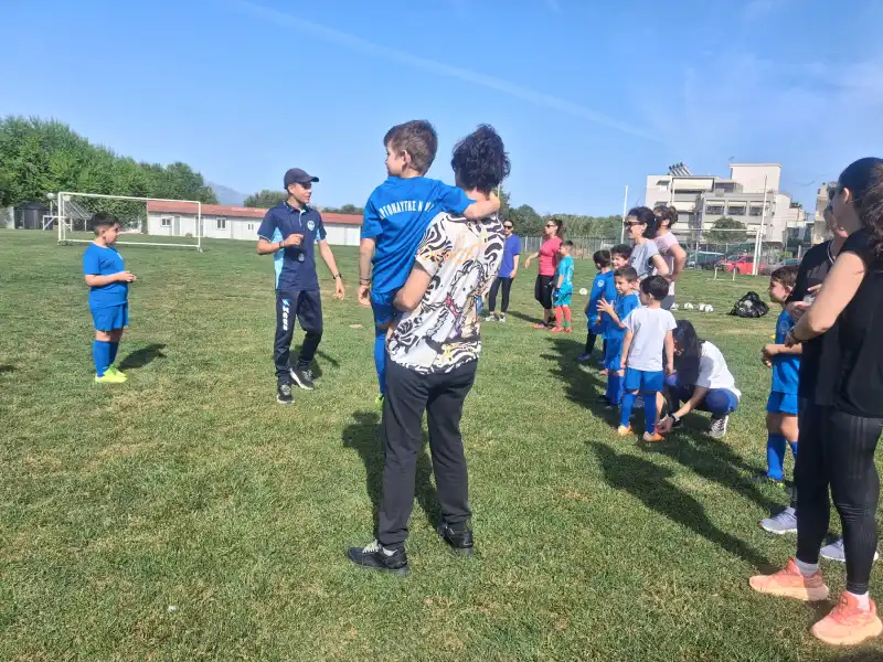 Μικροί αθλητές της Ακαδημίας Αργοναύτης Νέας Κίου προσφέρουν τριαντάφυλλα στις μητέρες τους.